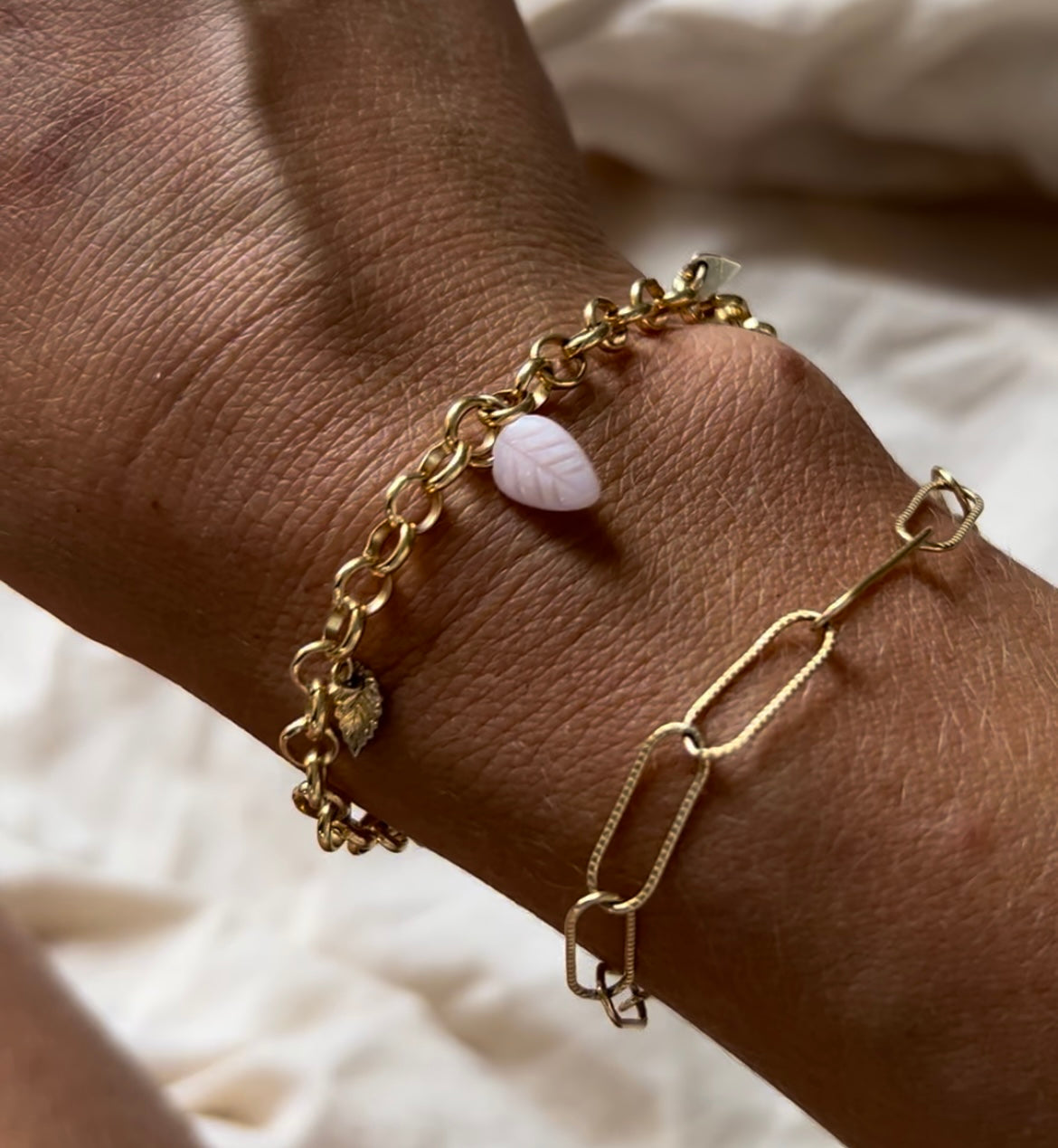 Chunky belcher chain bracelet with gold leaf and heart pendants and pink opal leaf.
